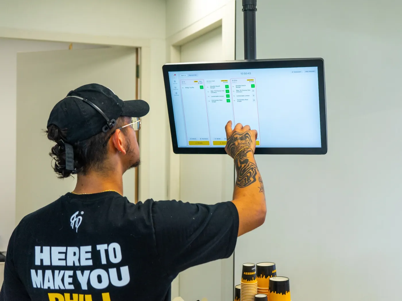 Fat Phill's team member ticking off a Drive-Thru order on the Onesix Kitchen Display