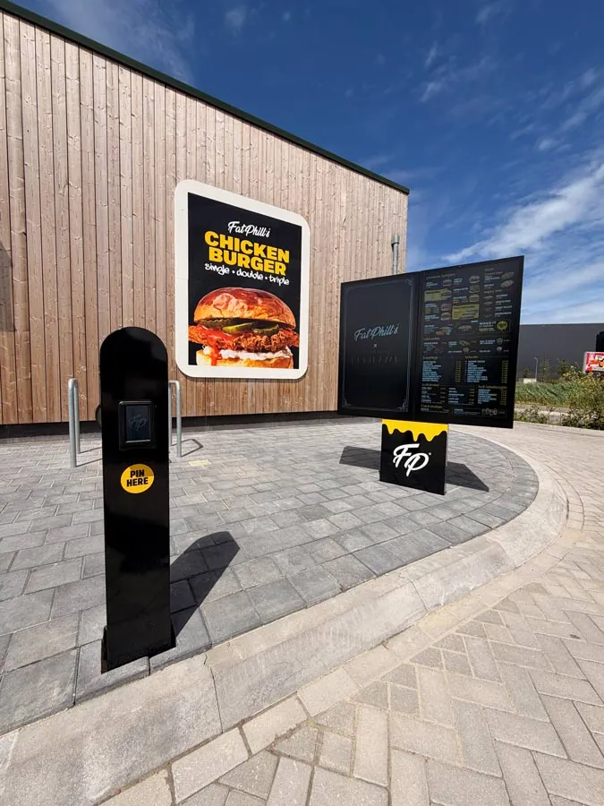 Post with intercom and payment terminal at the order point of the Fat Phill's Drive-Thru